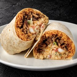 Fuego Cravings - Close up of A 13" flour tortilla packed with juicy shrimp, savory asada, rice, shredded cheese, pico, guacamole sauce, chipotle crema.