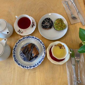 Callisto Tea House - Top: rose hibiscus tea pot + black sesame & avocado toast Bottom: ube cake + woodland spring green tea pot - Tea Rooms Near Me - Pasadena, California