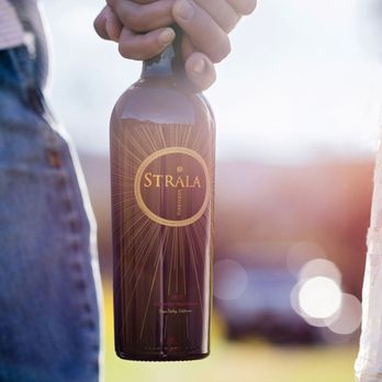 Strala Vineyards - a person holding a bottle of wine - Wine Tasting Room Near Me - St. Helena, California Strala Vineyards - a person holding a bottle of wine - Wine Tasting Room Near Me - St. Helena, California