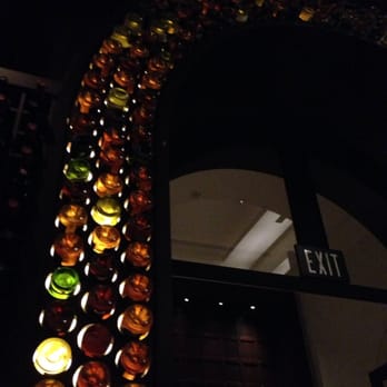 Bar Luna - a row of wine bottles on a wall - Bars Near Me - Boca Raton, Florida