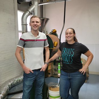 Great Minds Coffee Roasters - a man and a woman standing in front of a coffee roaster - Coffee Roasteries Near Me - Oakville, Connecticut Great Minds Coffee Roasters - a man and a woman standing in front of a coffee roaster - Coffee Roasteries Near Me - Oakville, Connecticut