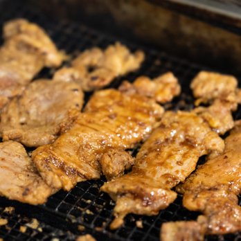 Pho79 - a close up of meat being cooked on a grill - Vietnamese Near Me - Washington, DC, District of Columbia