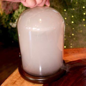Camelia Modern Mexican Cuisine - The Smoke on the Water was made with Mezcal, Genepy, rhum agricole, and lime - served in a coup glass in a smoke filled cloche. - Mexican Near Me - Denver, Colorado