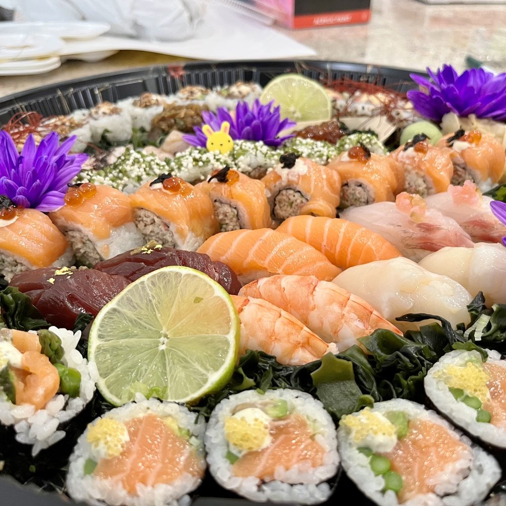 a platter of sushi with purple flowers a platter of sushi with purple flowers