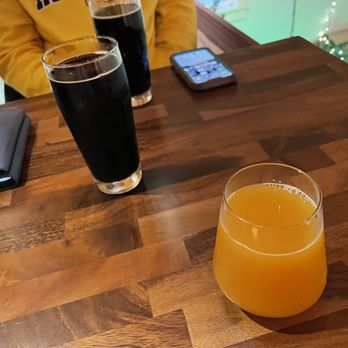 Aurora Brewing - a glass of orange juice on a wooden table - Breweries Near Me - Pittsford, New York Aurora Brewing - a glass of orange juice on a wooden table - Breweries Near Me - Pittsford, New York
