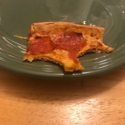 a slice of pepperoni pizza on a green plate