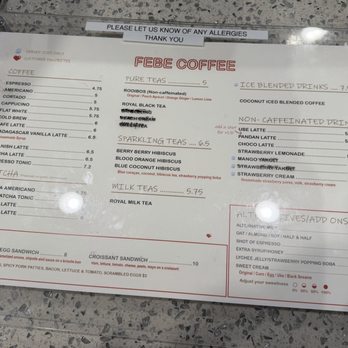 Febe Coffee - Menu as of Jan 2026 - The menu from Febe Coffee in Irvine, CA, displays a selection of coffee, matcha, teas, and non-caffeinated drinks with prices. It includes espresso, matcha, and various tea options such as rooibos, black tea, and berry hibiscus. The menu also offers specialty drinks like iced blended coffee, coconut iced blended coffee, and housemade strawberry cream. Additional options for milk and add-ons are listed in a section at the bottom right. The menu is printed on white paper with red and black text, placed on a speckled gray countertop. - Coffee & Tea Near Me - Irvine, California