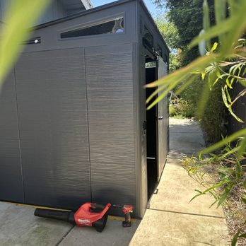 Fix-it Alex - Clean and compact setup of the Suncast Modernist 10x7 ft sliding door shed on a concrete pad -- perfect for organized outdoor storage. - Handyman Near Me Fix-it Alex - Clean and compact setup of the Suncast Modernist 10x7 ft sliding door shed on a concrete pad -- perfect for organized outdoor storage. - Handyman Near Me