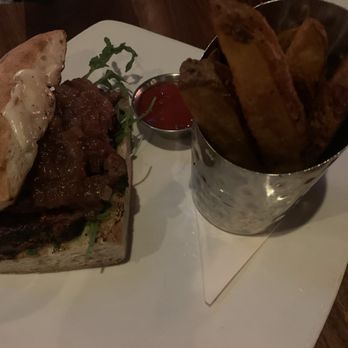 Foxhole Culinary Tavern - Wood fired steak sandwich and steak fries: petite chateau/ provolone/ onion jam/ arugula/ jalapeno aioli/ ciabatta - New American Near Me - Austin, Texas