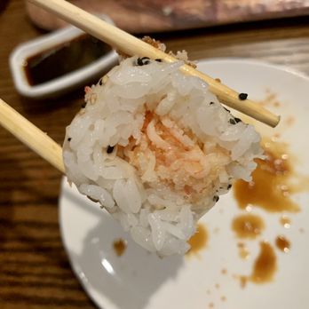 Sakura - chopsticks holding a piece of sushi - Sushi Bars Near Me - Akron, Ohio