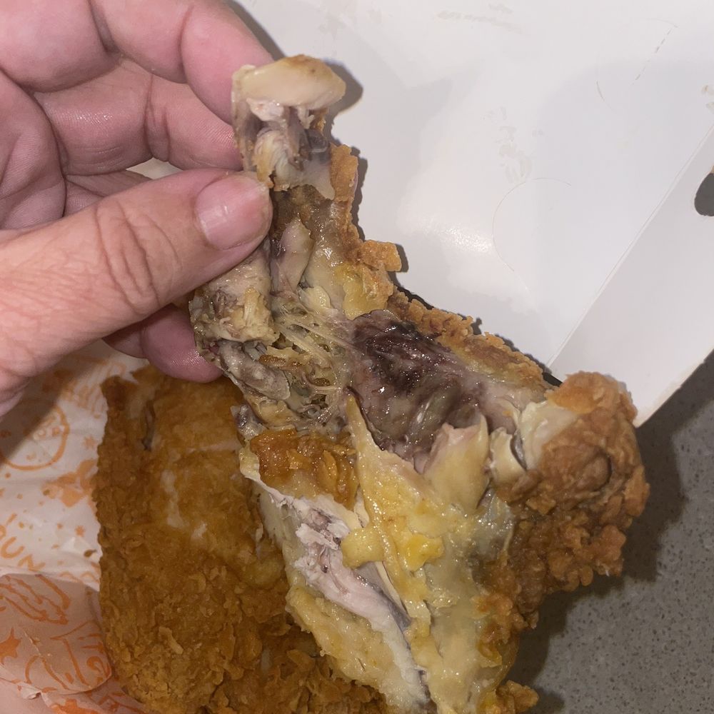 a hand holding a piece of fried chicken a hand holding a piece of fried chicken