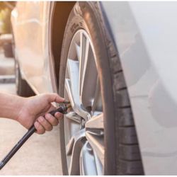 Air Roadside Assistance - Putting air in this customer's tires as she had a flat before leaving to work.