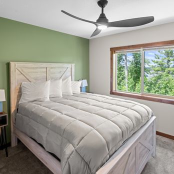 Big Sandy Lodge & Resort - Cabin 45: Cozy Upper Bedroom Featuring a Rustic Bed Frame, Lounge Chair, and Nightstand - Hotels Near Me - McGregor, Minnesota