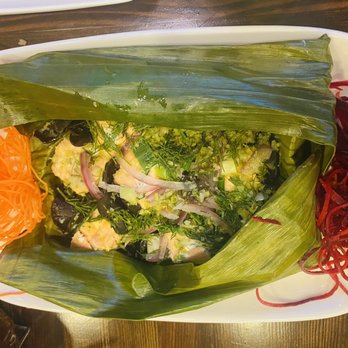 Thai Table - Bake salmon with mushroom and dill - A salad wrapped in banana leaf is presented on a white plate, accompanied by shredded carrots and beets on the side. - Thai Near Me - Frederick, Maryland