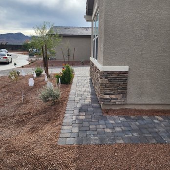 Luxurious Lawn Maintenance - a brick walkway leading to a house - Landscaping Near Me