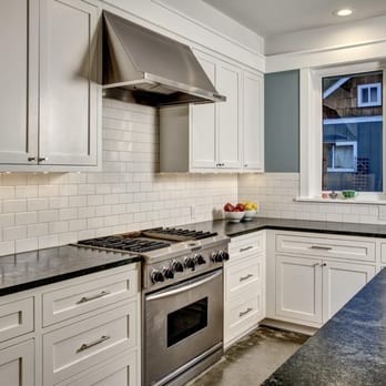 N & R Construction - a kitchen with white cabinets and black countertops - General Contractors Near Me - Seattle, Washington