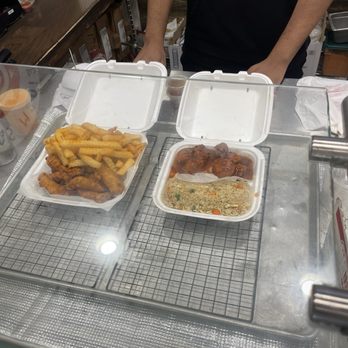 Wings Mania - our cashier showing the food, and asking what sauce we'd like on the side - Chicken Wings Near Me - Snellville, Georgia