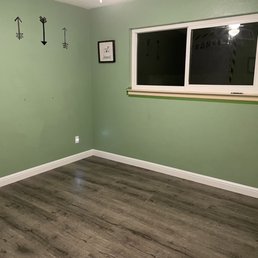 a room with green walls and wood floors