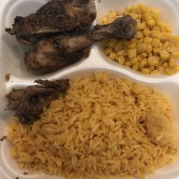Jerk chicken with yellow rice and corn.