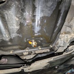 One Stop Lube & Oil - Leaking drain plug and oil residue on the bottom of the oil pan from it leaking.