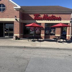 Tim Hortons - Store front with seating outside.
