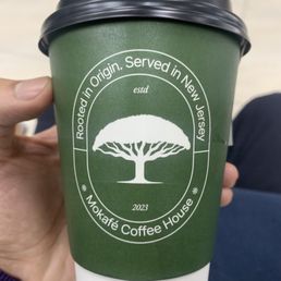 a hand holding a coffee cup