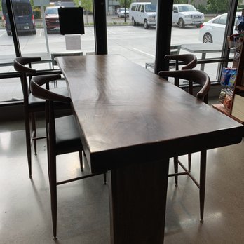 Urban Roast - a table and chairs in front of a large window - Coffee & Tea Near Me - Tukwila, Washington
