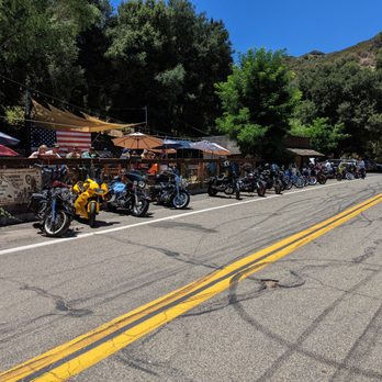 Josie’s Hideout Saloon - Motorcycle parking and behind it, the outdoor seating area adjacent to the stage, which is where you see the big American flag. - American Near Me - Santa Ysabel, California