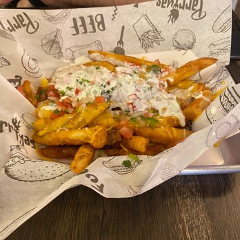 Parriyas - a person sitting at a table with a basket of fries - Colombian Near Me - West New York, New Jersey Parriyas - a person sitting at a table with a basket of fries - Colombian Near Me - West New York, New Jersey