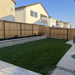Retaining wall, grass, stamped concrete pad, walkway, rocks... looks even better when the downlighting is on!