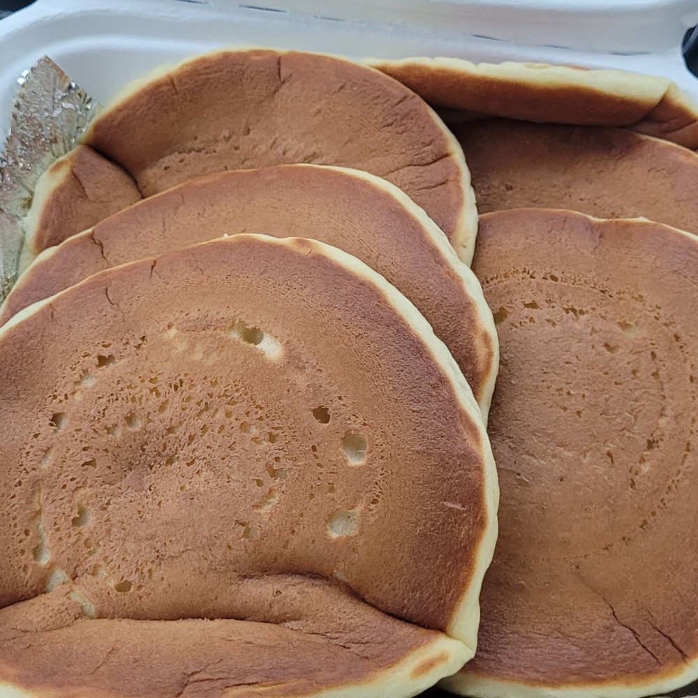 An order of buttermilk pancakes served with whipped butter and syrup. An order of buttermilk pancakes served with whipped butter and syrup.