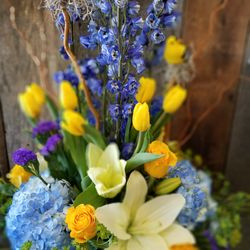 Spring yellow blue white funeral sympathy flowers.