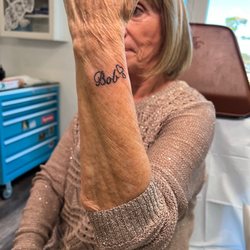 Oddity Tattoo Art University - This is my mother-in-law with her finished tattoo with my father-in-law's name and two hearts.