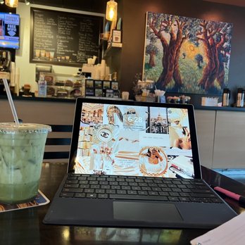 Coffee District - a laptop and a drink on a table - Coffee & Tea Near Me - Delray Beach, Florida