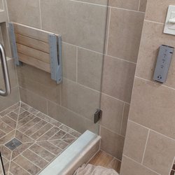 SST Construction - Bathroom transformation featuring new tile, cabinetry, and upgraded fixtures.