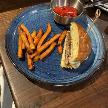 Eureka! - Half of a bison burger with sweet potato fries. - American Near Me - Austin, Texas