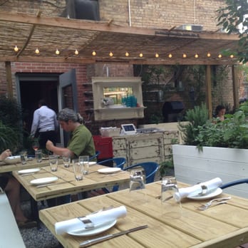 L'Antagoniste - Dining al fresco in the L'Antagoniste garden, planted with blue and purple flowers. - French Near Me - Brooklyn, New York L'Antagoniste - Dining al fresco in the L'Antagoniste garden, planted with blue and purple flowers. - French Near Me - Brooklyn, New York