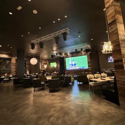 Nellie's Southern Kitchen - Stage and tv area with tables and lounge areas