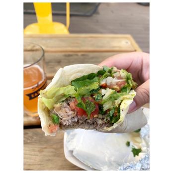 Taco Baby - a hand holding a burrito - Food Trucks Near Me