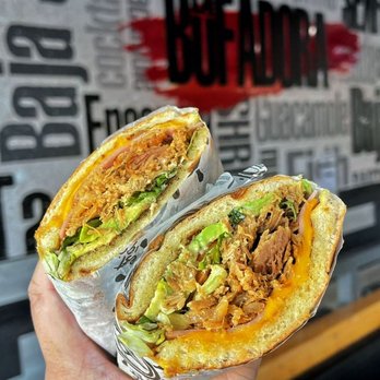 La Bufadora Baja Grill - Riverside - a hand holding a burrito - Mexican Near Me - Riverside, California La Bufadora Baja Grill - Riverside - a hand holding a burrito - Mexican Near Me - Riverside, California