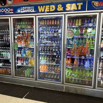 Eddies Market - Refrigerated beverage coolers filled with sodas, energy drinks, and bottled coffee at a convenience store. - Grocery Near Me - Albuquerque, New Mexico