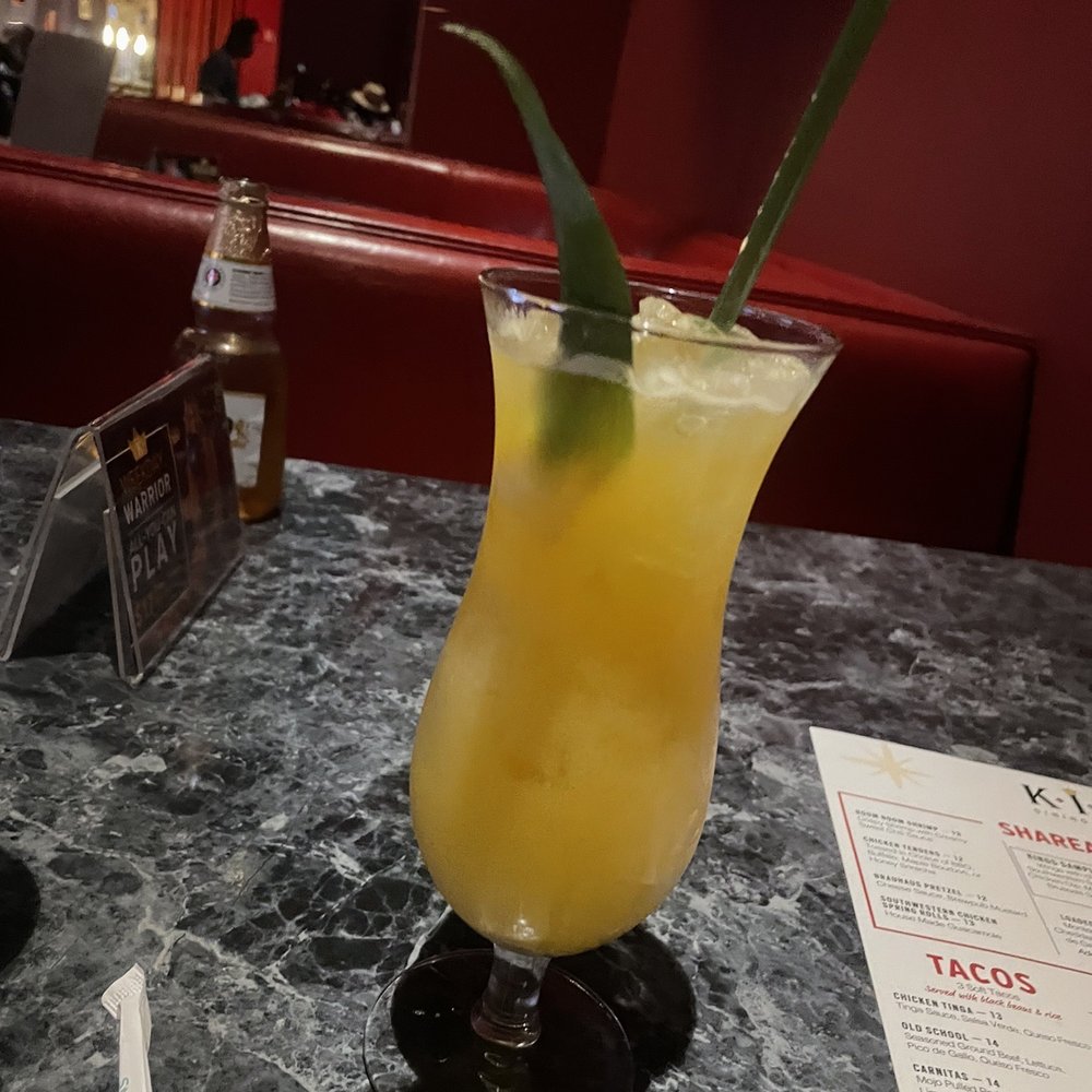 Kings Dining & Entertainment - a cocktail in a tall glass with a green leaf - American Near Me - Raleigh, North Carolina Kings Dining & Entertainment - a cocktail in a tall glass with a green leaf - American Near Me - Raleigh, North Carolina