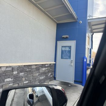 Dutch Bros Coffee - The image shows a blue exterior wall of a building with a gray door labeled 'Broista Entrance' and a pointing hand graphic. A blue post and security camera are also visible. - Coffee & Tea Near Me - Albuquerque, New Mexico