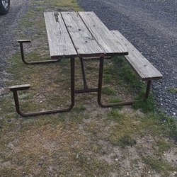 Clayton RV Park - Picnic table is missing an entire seat, leaving bare metal exposed.
