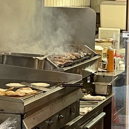Photo of La Taqueria - San Francisco, CA, United States. Carne asada being grilled
