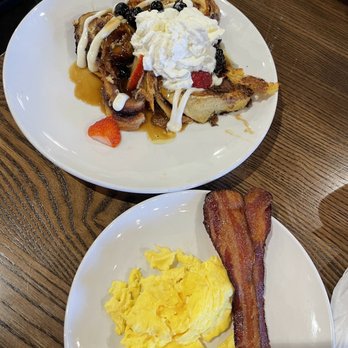 Another Broken Egg Cafe - Cinnamon roll pancakes/waffles with a side of eggs with bacon - American Near Me - Orlando, Florida