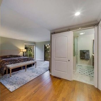 MCM - a bedroom with a large bed and sliding glass doors - General Contractors Near Me MCM - a bedroom with a large bed and sliding glass doors - General Contractors Near Me