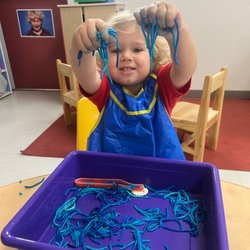 Maple Bear Tempe - Hands-on fun! This Preschooler at Maple Bear Tempe is developing fine motor skills with exciting, sensory play. So many smiles!
