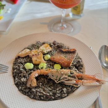 BCN Taste & Tradition - Bomba rice cooked in cuttlefish's black ink, grilled branzino, langoustine, and octopus - Catalan Near Me - Houston, Texas