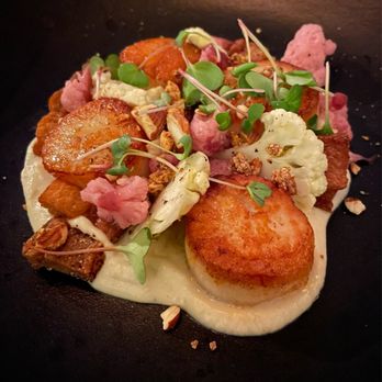 jjacques - a scallop dish on a black plate - Cocktail Bars Near Me - Quebec City, Quebec